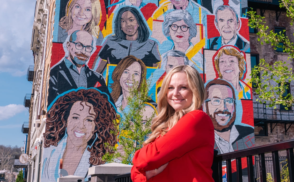 Angela Hall in front of the 2024 Alumni Mural