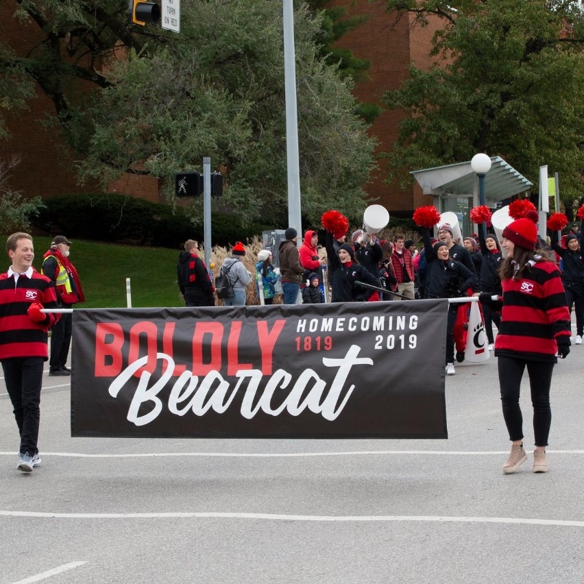 SAC student carrying the Boldly Bearcat parade sign