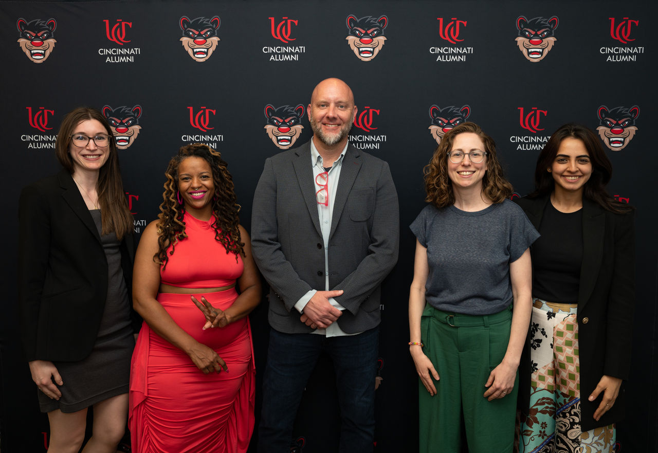 DAAP Alumni in front of a UC photo backdrop