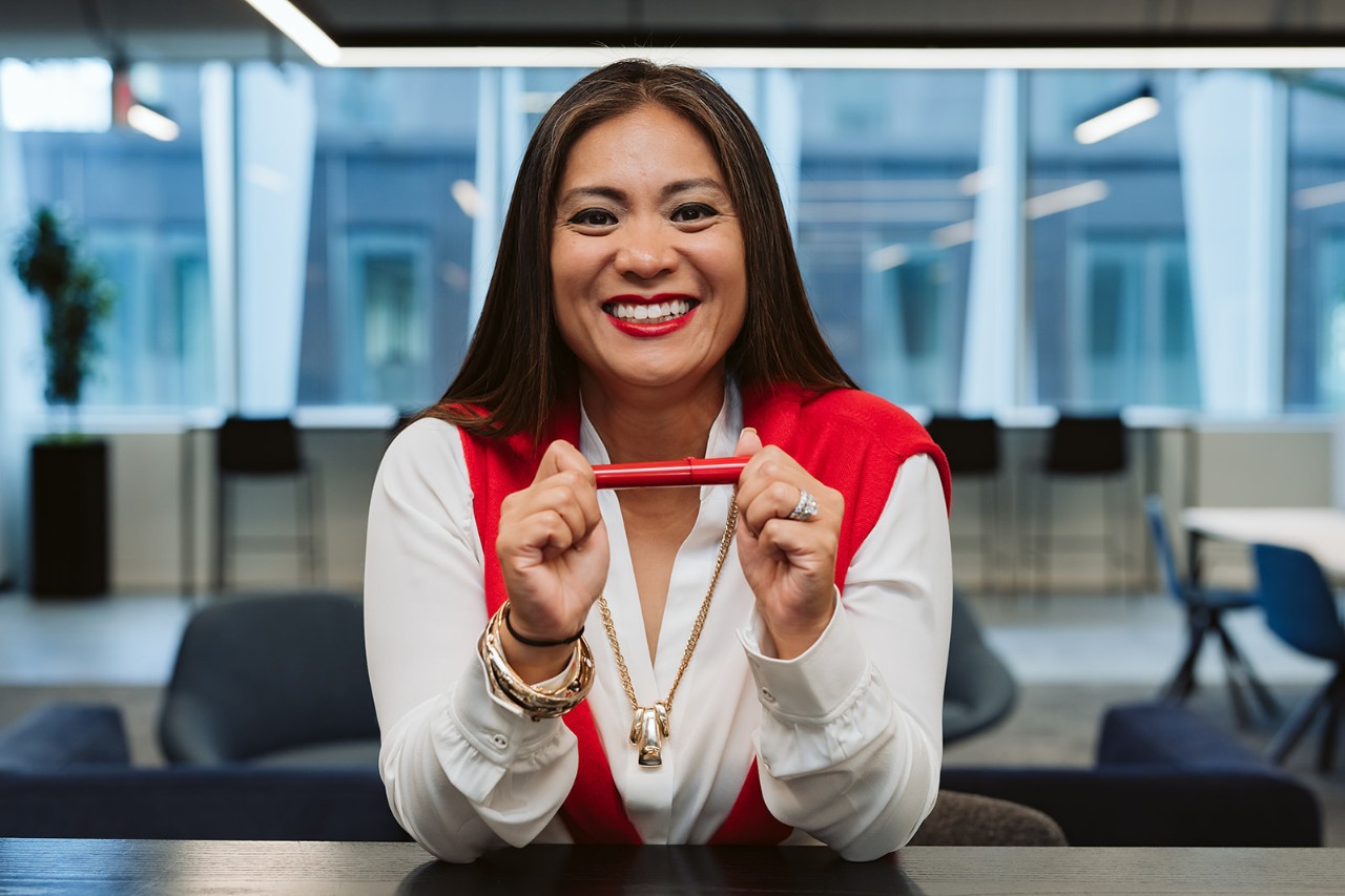 Woman smiling while holding a red marker